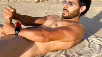 Tío musculoso tatuado se paja su gran polla en playa nudista