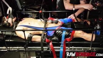 O mestre domina o atleta em máscara de gás com bomba de pau e fisting