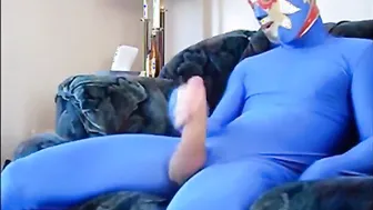 Mysteriöser mann im blauen zentai-anzug streichelt seinen großen sc...