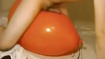 Jovencito folla un gran globo naranja inflable hasta correrse