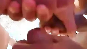 Tres hombres chupando pollas en una playa pública