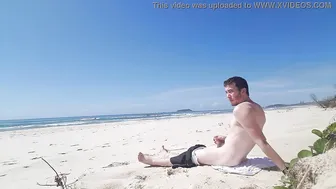 Twink branle sa bite sur une plage publique ensoleillée