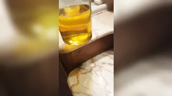 Dünner italienischer twink füllt ein glas mit goldenem pisse